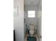 Bathroom with toilet, shower with decorative curtains, window, and tiled floors at 882 Redwood Way, Lake Wales, FL 33898