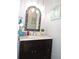 Stylish bathroom featuring dark vanity with marble countertop, decorative mirror, and updated fixtures at 882 Redwood Way, Lake Wales, FL 33898