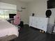 Bedroom features a white dresser, pink gaming chair, and dark wood floors at 882 Redwood Way, Lake Wales, FL 33898
