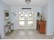 Inviting foyer area featuring neutral walls, tile flooring, a decorative table, and an ornate cabinet at 882 Redwood Way, Lake Wales, FL 33898