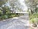 Charming single-story home with a driveway and a lush, landscaped front yard featuring mature trees at 882 Redwood Way, Lake Wales, FL 33898