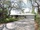 Single-story home with a well-manicured front yard, beautiful landscaping, and long driveway at 882 Redwood Way, Lake Wales, FL 33898