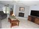 Comfortable living room with a gray brick fireplace, tile floors, and a ceiling fan for added comfort at 882 Redwood Way, Lake Wales, FL 33898