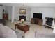 Cozy living room with gray sofas, a fireplace, tile floors, and a ceiling fan at 882 Redwood Way, Lake Wales, FL 33898