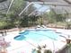 Sparkling pool with screened in lanai, lounge chairs and landscaping at 882 Redwood Way, Lake Wales, FL 33898