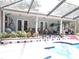 Spacious outdoor patio with a screened-in pool area, featuring comfortable seating and a lush garden at 882 Redwood Way, Lake Wales, FL 33898