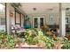 Cozy screened porch with comfortable seating, plants, and a view of the backyard at 882 Redwood Way, Lake Wales, FL 33898