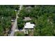 Aerial view of a single-Gathering home with a white roof nestled among lush trees at 9365 Lemon Dr, Lake Wales, FL 33898