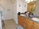 Bright bathroom featuring a double vanity with wood cabinets and tile flooring at 9365 Lemon Dr, Lake Wales, FL 33898