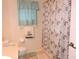 Inviting bathroom with decorative shower curtain, window, and tile flooring at 9365 Lemon Dr, Lake Wales, FL 33898