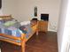Bedroom features rustic log bed, hardwood floors and a cow portrait at 9365 Lemon Dr, Lake Wales, FL 33898