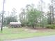 View of large lot with storage structure with metal roof and natural landscaping at 9365 Lemon Dr, Lake Wales, FL 33898