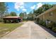 View of the side exterior of the home, with a long driveway and metal carport at 9365 Lemon Dr, Lake Wales, FL 33898