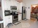 Well-equipped kitchen featuring stainless steel appliances, white cabinets, and tile floors at 9365 Lemon Dr, Lake Wales, FL 33898