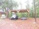 View of open-sided outbuilding with roof, trailer and ATV on lot with natural landscaping at 9365 Lemon Dr, Lake Wales, FL 33898