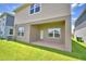 Exterior view of home from backyard featuring patio, windows, door, and grassy lawn at 1417 Leamington Ln, Winter Haven, FL 33884