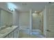 Bathroom features a tiled shower, a soaking tub, double sinks, and granite countertops at 1417 Leamington Ln, Winter Haven, FL 33884