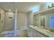 Bathroom features a tiled shower, a soaking tub, double sinks, granite countertops, and modern lighting at 1417 Leamington Ln, Winter Haven, FL 33884