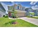 Inviting two-story home with a lush green lawn, spacious driveway, and beautiful landscaping at 1417 Leamington Ln, Winter Haven, FL 33884