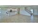 Open-concept living area with a large tile floor, kitchen and staircase at 1417 Leamington Ln, Winter Haven, FL 33884