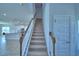 Carpeted staircase with white risers and wooden handrail, leading to an open-concept living area at 1417 Leamington Ln, Winter Haven, FL 33884