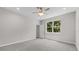 Spacious bedroom featuring plush carpeting, a ceiling fan, and a large window at 4502 Fairway Oaks Dr, Mulberry, FL 33860