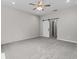 Spacious bedroom with gray carpet, ceiling fan, and a sliding barn door to the bathroom at 4502 Fairway Oaks Dr, Mulberry, FL 33860