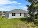 A single-story home with white exterior, green lawn, and large windows offering ample natural light at 4502 Fairway Oaks Dr, Mulberry, FL 33860