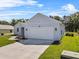 A single story home with a two car garage, small garden in front, and a green lawn in the front yard at 4502 Fairway Oaks Dr, Mulberry, FL 33860