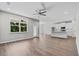 Bright living room with hardwood floors, ceiling fan, and a large window overlooking lush greenery at 4502 Fairway Oaks Dr, Mulberry, FL 33860
