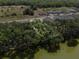Aerial view of a vacant lot surrounded by trees and adjacent to a lake at 4537 Fairway Oaks Dr, Mulberry, FL 33860
