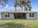 Back exterior view of home with covered patio, green lawn and exterior neutral colored paint at 4537 Fairway Oaks Dr, Mulberry, FL 33860