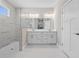 Bright bathroom with a double sink vanity, glass shower and marble-look flooring at 4537 Fairway Oaks Dr, Mulberry, FL 33860
