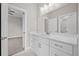 Well-lit bathroom vanity featuring a large mirror, white cabinets, and modern fixtures with a bedroom view at 4537 Fairway Oaks Dr, Mulberry, FL 33860
