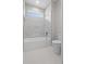 Bright bathroom with a shower and tub combination featuring white tiled walls and flooring at 4537 Fairway Oaks Dr, Mulberry, FL 33860