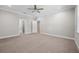 Large bedroom with neutral walls, carpet, ceiling fan, and multiple doors at 4537 Fairway Oaks Dr, Mulberry, FL 33860