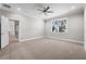 Spacious bedroom with a ceiling fan, neutral carpet, and a view to trees through the window at 4537 Fairway Oaks Dr, Mulberry, FL 33860