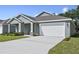 Charming single-story home featuring a well-maintained lawn, a two-car garage, and neutral, stylish exterior paint at 4537 Fairway Oaks Dr, Mulberry, FL 33860
