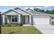 Well-maintained single-story home with neutral exterior, manicured lawn, and convenient two-car garage at 4537 Fairway Oaks Dr, Mulberry, FL 33860