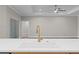 Modern kitchen sink with white countertops and a stylish gold faucet, overlooking a spacious living area at 4537 Fairway Oaks Dr, Mulberry, FL 33860