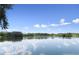 Scenic lake view featuring beautiful sky, lush green trees, and reflections on the water, offering tranquility at 4537 Fairway Oaks Dr, Mulberry, FL 33860