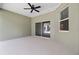 A spacious covered outdoor patio features a ceiling fan and large sliding glass doors leading to the backyard at 4537 Fairway Oaks Dr, Mulberry, FL 33860