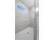Walk-in shower with marble tile and glass partition, lit by transom window at 4537 Fairway Oaks Dr, Mulberry, FL 33860