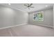 Bright, carpeted bedroom featuring a large window with outside view and a ceiling fan at 4541 Fairway Oaks Dr, Mulberry, FL 33860