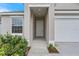 Charming front porch with white trim, landscaping, and a white garage door at 4541 Fairway Oaks Dr, Mulberry, FL 33860