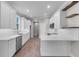 Modern kitchen with white cabinetry, quartz countertops, stainless steel appliances and wood-look floors at 4541 Fairway Oaks Dr, Mulberry, FL 33860