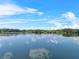Scenic lake view reflecting blue skies and clouds surrounded by lush greenery, enhancing the tranquil setting at 4541 Fairway Oaks Dr, Mulberry, FL 33860