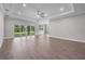 Large living room with wood-look flooring, fan, and sliding glass doors to the outdoor space at 4541 Fairway Oaks Dr, Mulberry, FL 33860