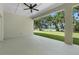 Covered patio with ceiling fan offering serene views of the lush backyard and tranquil lake at 4541 Fairway Oaks Dr, Mulberry, FL 33860