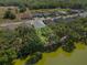 A high aerial view of a well maintained single-Gathering home bordered by mature trees and a pond at 4545 Fairway Oaks Dr, Mulberry, FL 33860